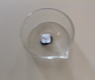 Allume di rocca dentro un becker