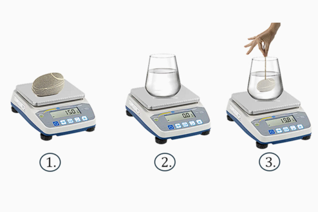 Alcune fasi della misura del peso:1) un sasso da solo sulla bilancia, 2) un bicchiere pieno di acqua sulla bilancia azzerata, 3) il sasso immerso in acqua ma sospeso